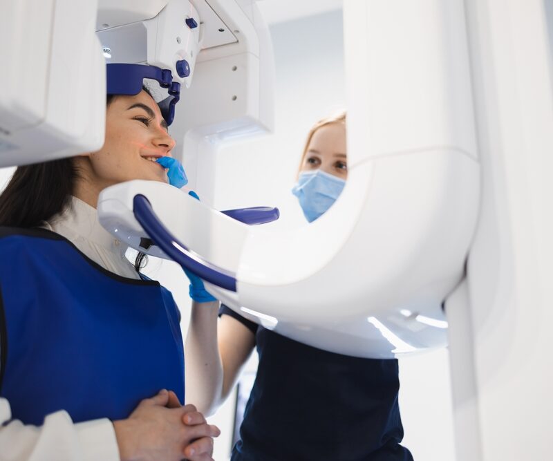 Female patient make a dental computer tomograph. The radiologist makes a CT scan of the jaw